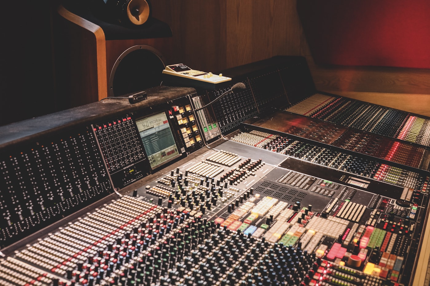 A large mixing console with rows of colored channel strips.