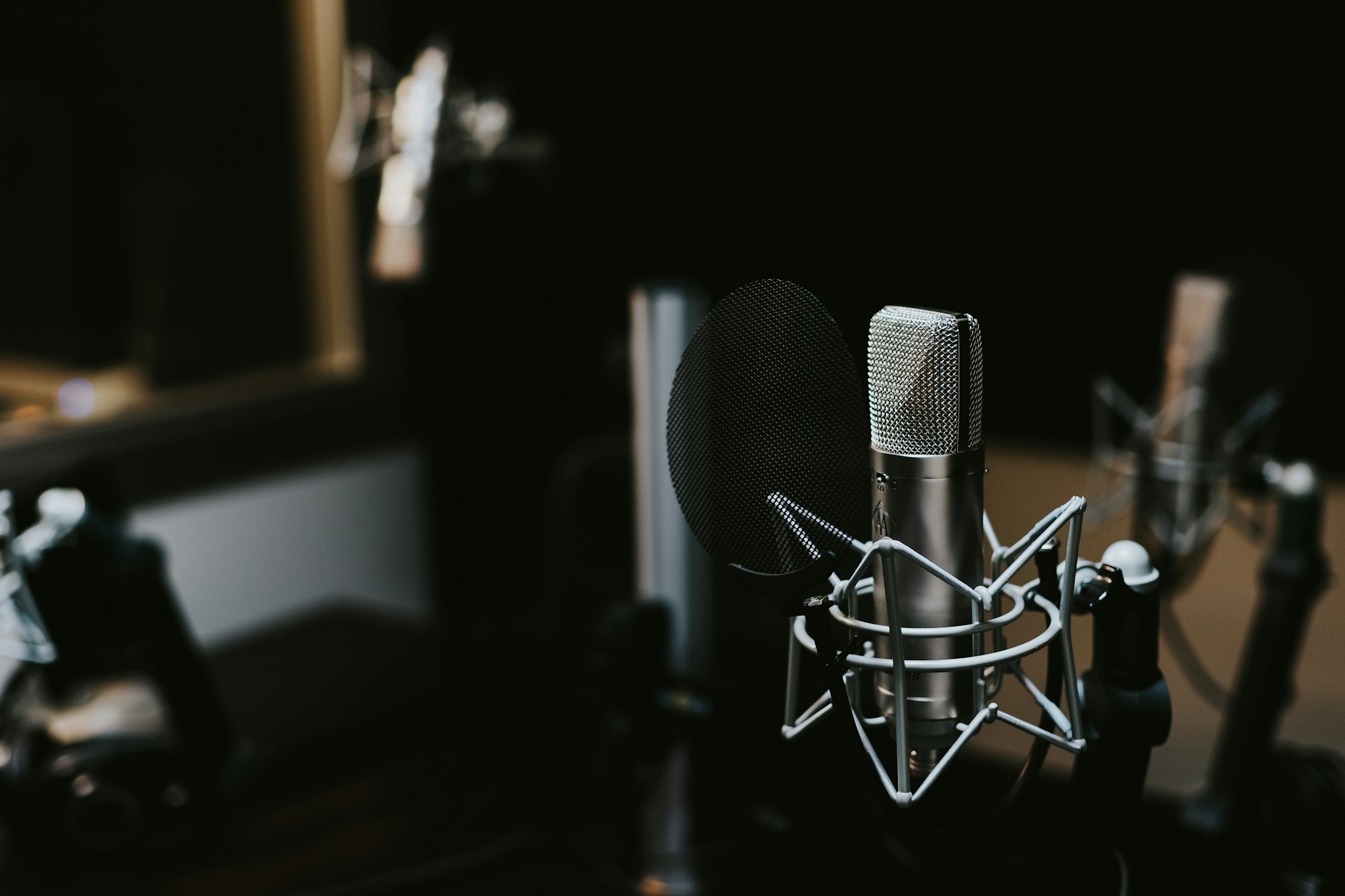 A dim vocal booth with a microphone ready to record.