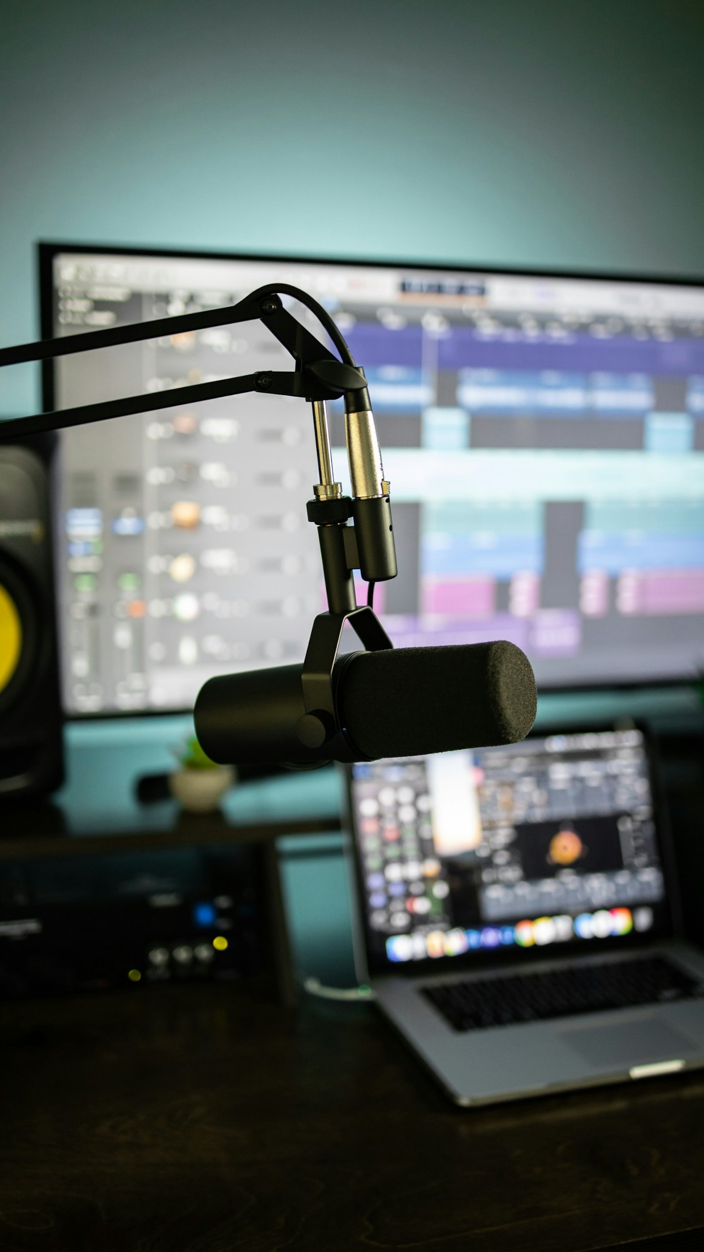 A broadcast podcast microphone on a boom arm in a studio.